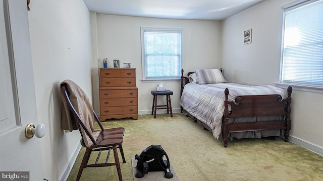 carpeted bedroom with baseboards and multiple windows