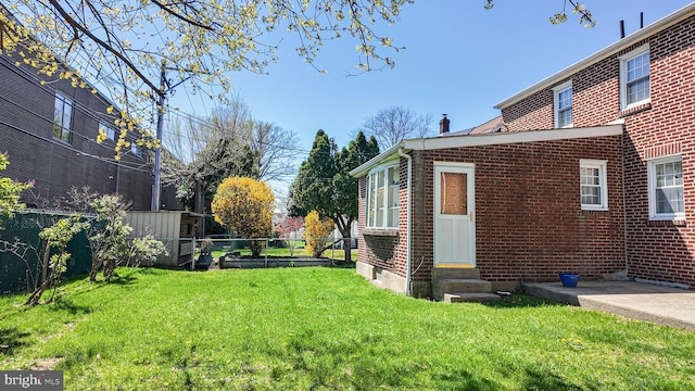 view of yard featuring entry steps and fence