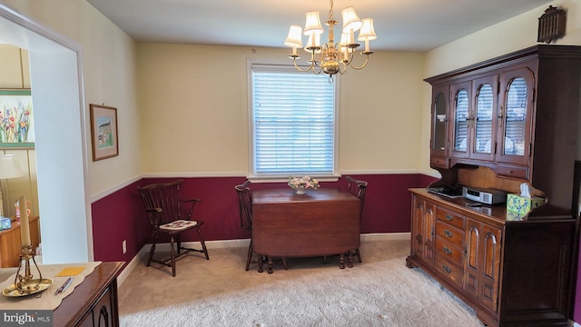 living area featuring a chandelier, carpet, and baseboards