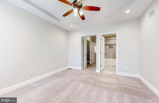 unfurnished bedroom with baseboards, recessed lighting, visible vents, a tray ceiling, and light colored carpet