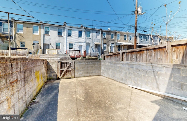 view of patio with a gate, fence, and a residential view