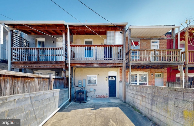 view of front of house featuring brick siding, central air condition unit, and fence