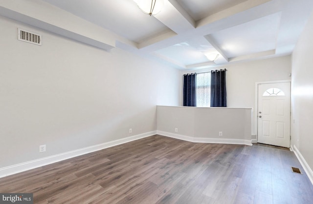 spare room with visible vents, baseboards, beamed ceiling, dark wood-type flooring, and coffered ceiling