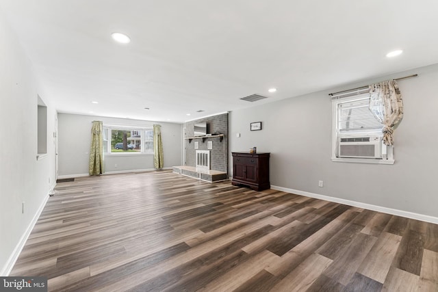 unfurnished living room featuring wood finished floors, cooling unit, recessed lighting, and baseboards