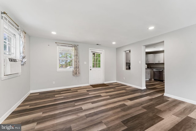 unfurnished living room with recessed lighting, cooling unit, dark wood finished floors, and baseboards