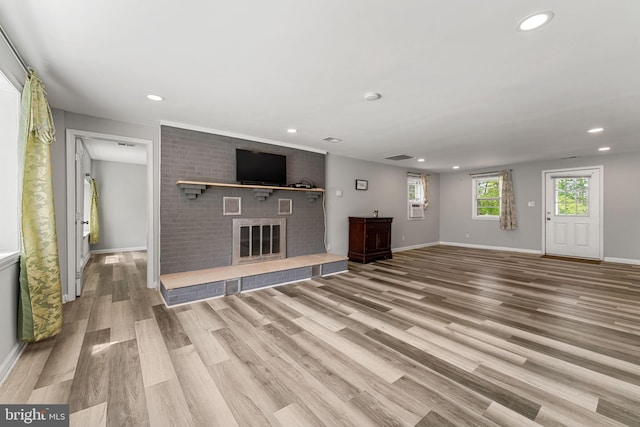 unfurnished living room with recessed lighting, wood finished floors, and a fireplace