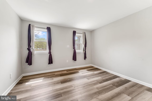 empty room featuring wood finished floors and baseboards
