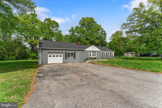ranch-style home featuring a front yard, a garage, and aphalt driveway