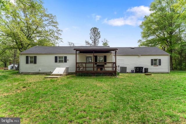rear view of property with a deck, cooling unit, and a yard