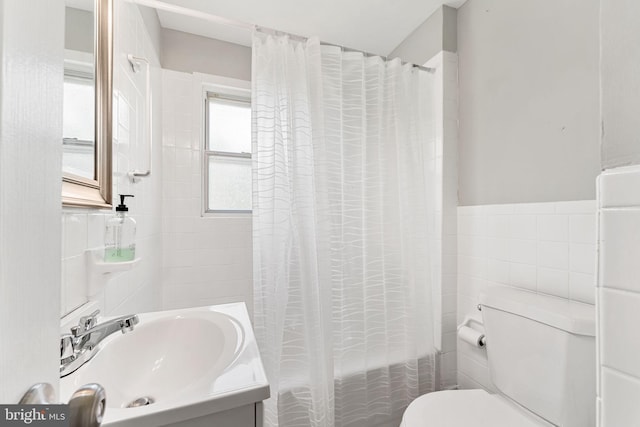 bathroom featuring shower / tub combo, tile walls, toilet, and vanity