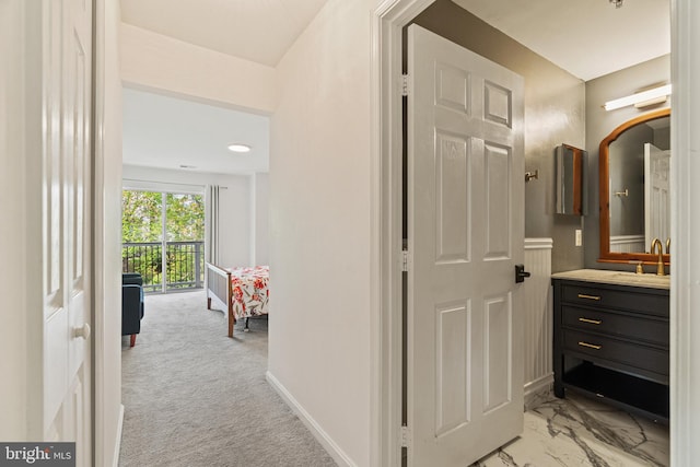 20605 Cornstalk Ter Unit 201, Ashburn, VA 20147 - hallway featuring light colored carpet, a sink, marble finish floor, and baseboards
