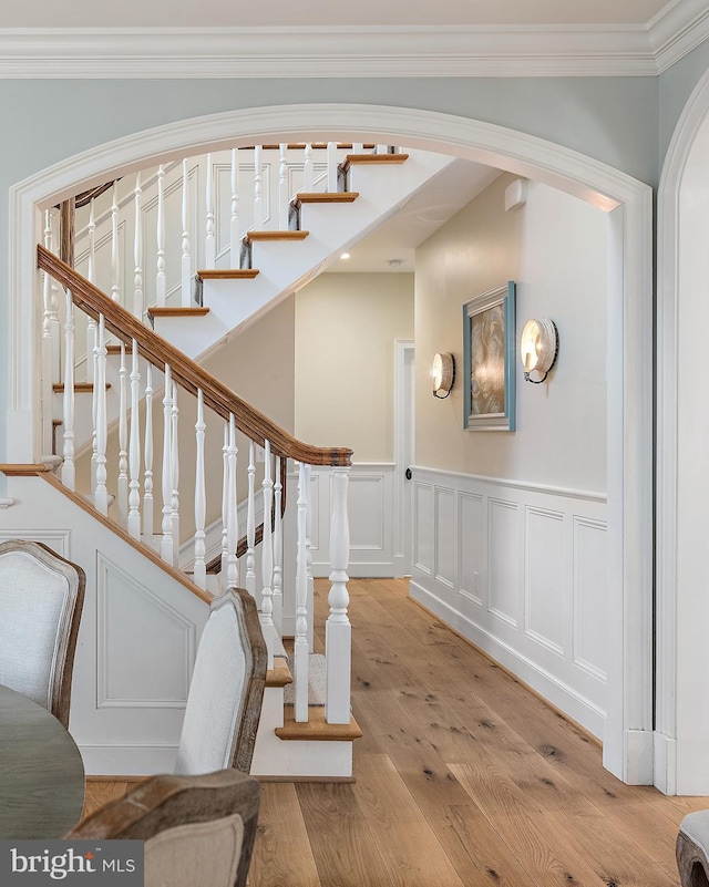 208 Wardour Dr, Annapolis, MD 21401 - stairs featuring a wainscoted wall, wood finished floors, ornamental molding, arched walkways, and a decorative wall