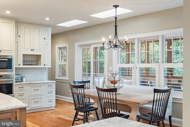 208 Wardour Dr, Annapolis, MD 21401 - dining room with a skylight, an inviting chandelier, light wood-style flooring, baseboards, and recessed lighting