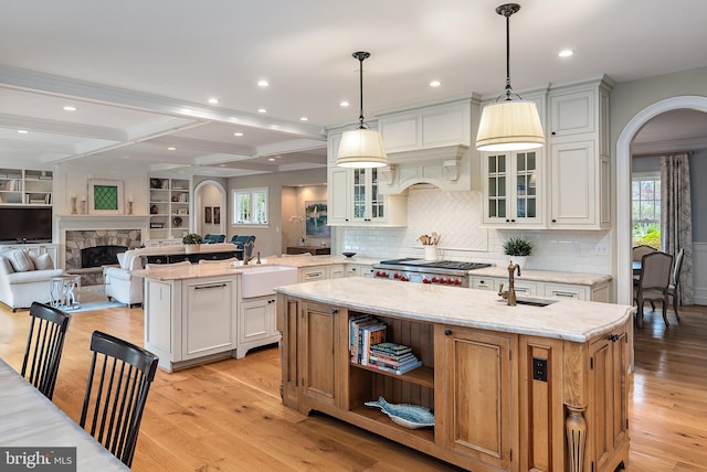 208 Wardour Dr, Annapolis, MD 21401 - kitchen with a sink, light wood-style floors, a kitchen island with sink, arched walkways, and recessed lighting