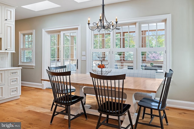 208 Wardour Dr, Annapolis, MD 21401 - dining room with light wood-style flooring, a skylight, baseboards, and a notable chandelier
