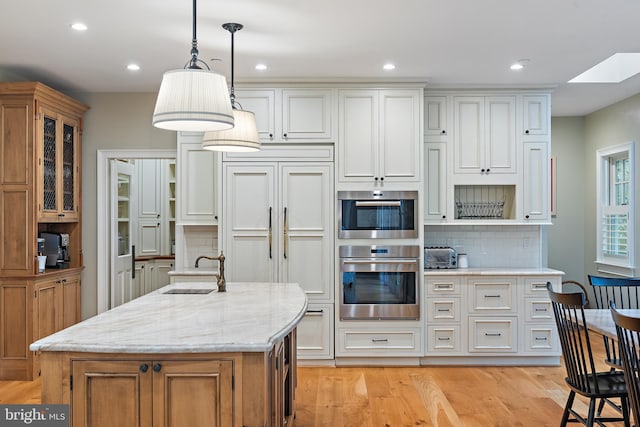 208 Wardour Dr, Annapolis, MD 21401 - kitchen with backsplash, light stone counters, a sink, and light wood-style flooring