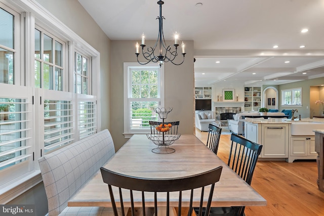 208 Wardour Dr, Annapolis, MD 21401 - dining room featuring recessed lighting, an inviting chandelier, a stone fireplace, beam ceiling, and light wood-style flooring