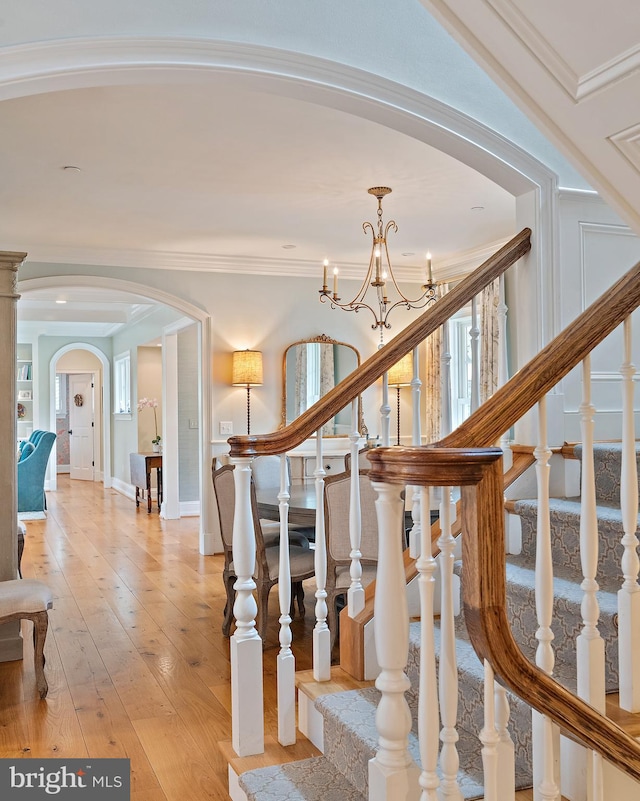 208 Wardour Dr, Annapolis, MD 21401 - stairs with hardwood / wood-style flooring, arched walkways, a chandelier, and crown molding