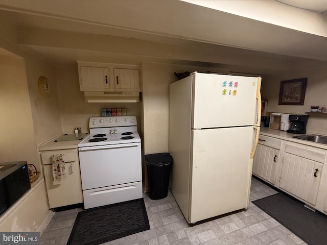 kitchen featuring under cabinet range hood, white appliances, light countertops, and a sink