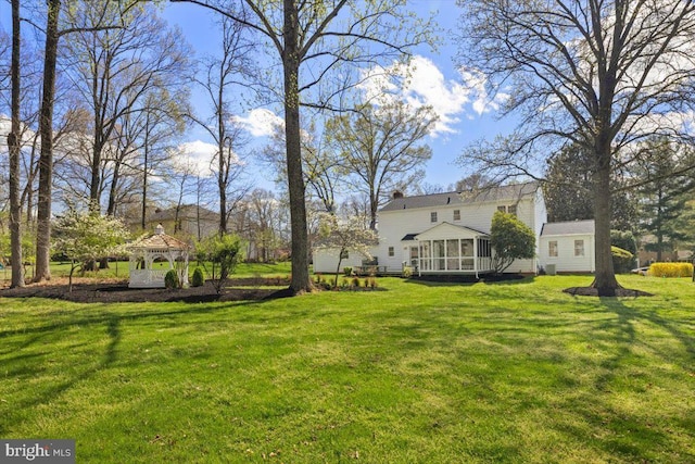 view of yard featuring a sunroom and a gazebo