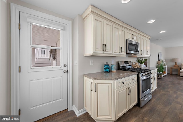kitchen with cream cabinetry, dark wood-type flooring, recessed lighting, and stainless steel appliances