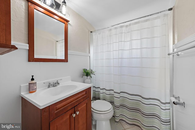 bathroom with toilet, vanity, and a shower with shower curtain
