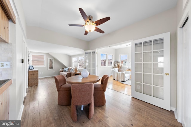 dining room featuring wood finished floors, baseboards, and a ceiling fan