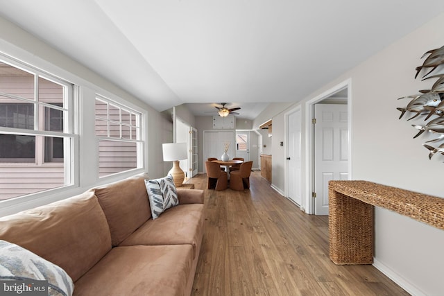 living area featuring ceiling fan, wood-type flooring, and baseboards