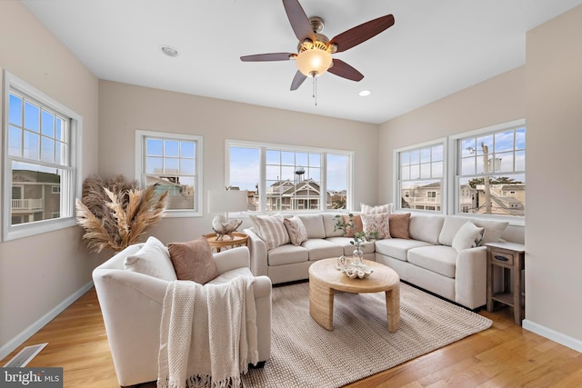 living room with visible vents, a wealth of natural light, and light wood-style floors