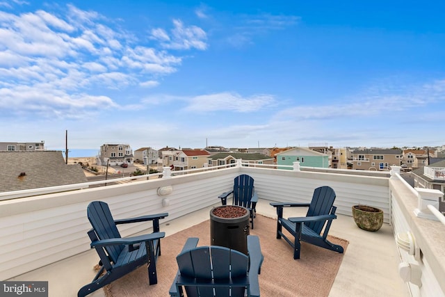 view of patio with an outdoor fire pit, outdoor dining area, a residential view, and a balcony