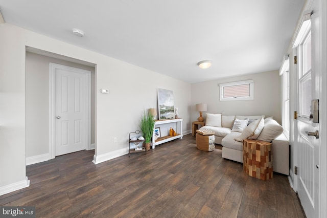 living area with dark wood-style flooring and baseboards