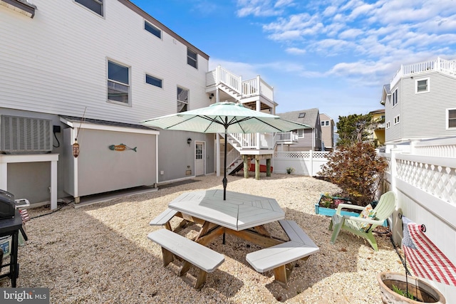 view of patio featuring stairs, a residential view, central air condition unit, and a fenced backyard