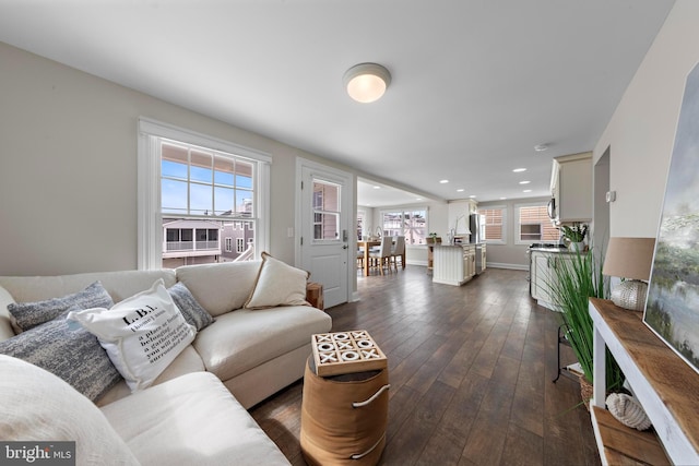 living area with recessed lighting, dark wood-style floors, and baseboards