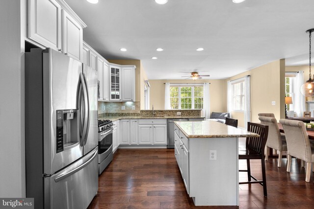kitchen featuring a sink, appliances with stainless steel finishes, a breakfast bar area, and white cabinetry