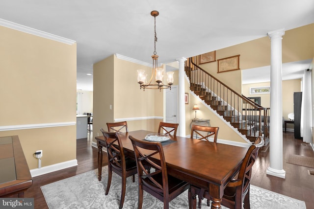 dining room with ornate columns, a notable chandelier, wood finished floors, and stairway