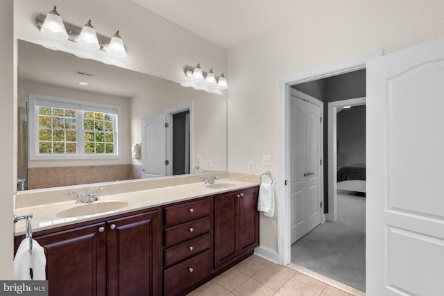 bathroom featuring double vanity, visible vents, a sink, and tile patterned flooring