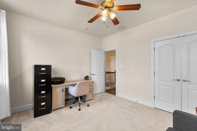 home office with baseboards, ceiling fan, light carpet, and visible vents