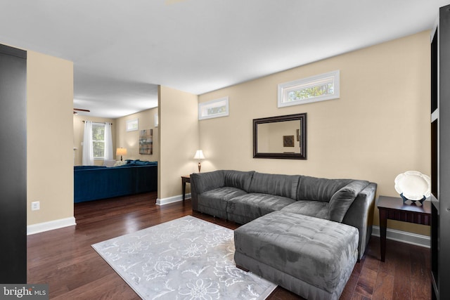 living area with baseboards, a ceiling fan, and wood finished floors