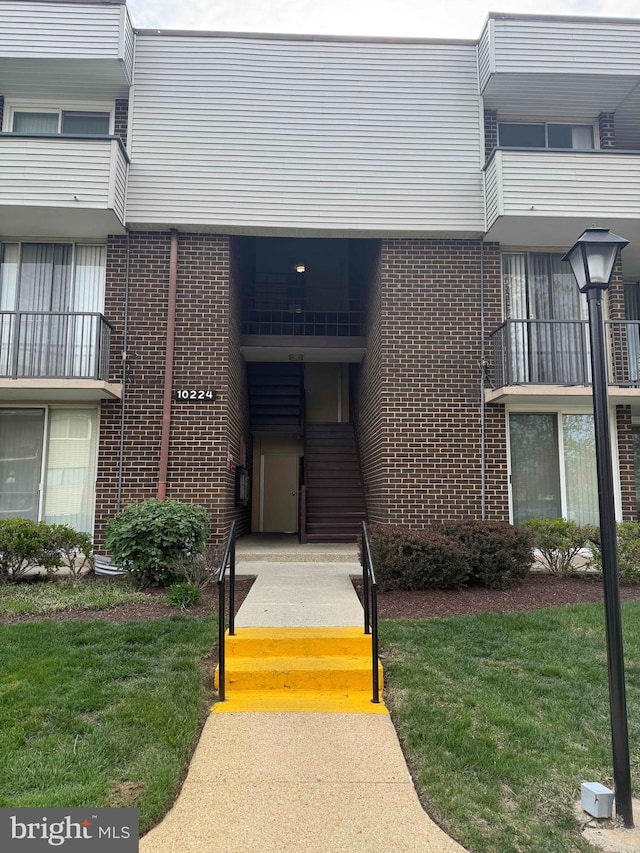 10224 Prince Pl Unit 12-307, Upper Marlboro, MD 20774 - doorway to property featuring brick siding and a yard