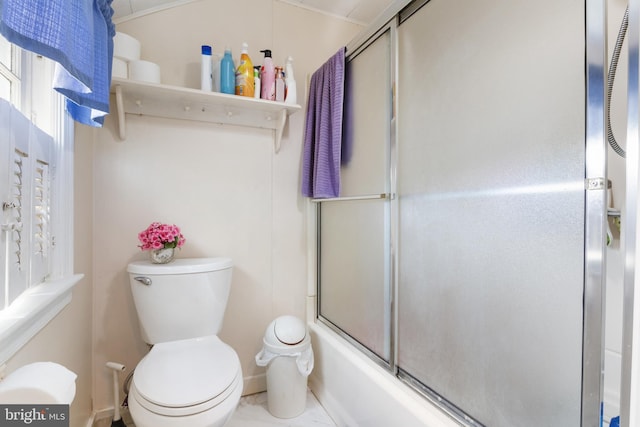 full bathroom featuring toilet and bath / shower combo with glass door