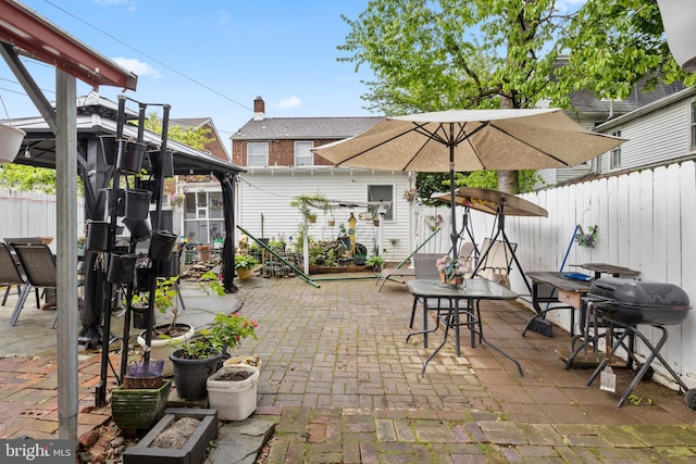 view of patio featuring a gazebo, fence, and area for grilling