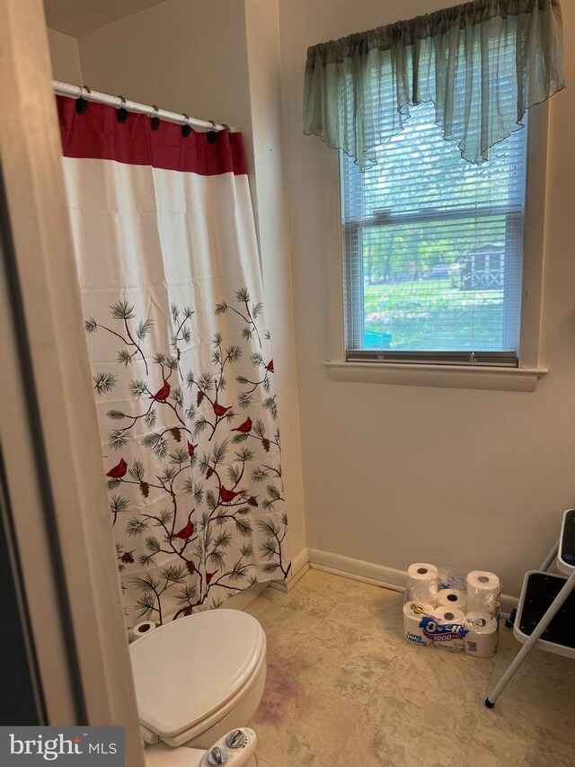 full bathroom featuring curtained shower, toilet, baseboards, and tile patterned floors
