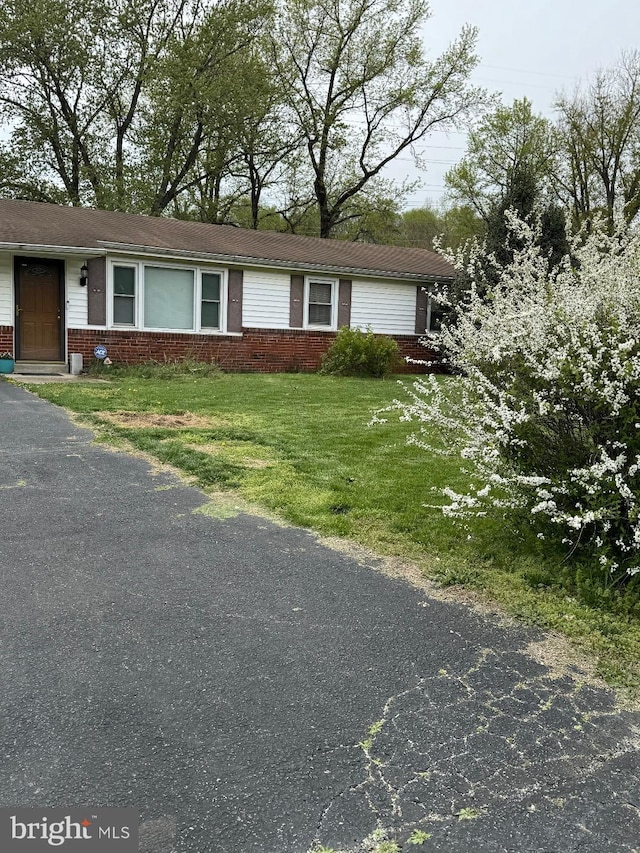 ranch-style house with brick siding and a front yard