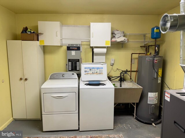clothes washing area featuring cabinet space, electric water heater, and independent washer and dryer