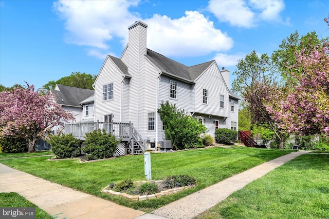 view of home's exterior featuring a wooden deck, cooling unit, a chimney, a yard, and stairway