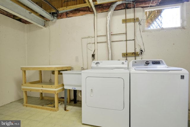 washroom featuring laundry area, a sink, washer and clothes dryer, and tile patterned floors