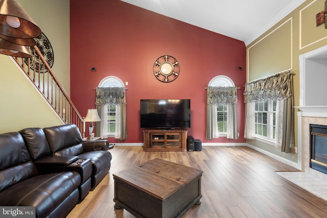 1 Pinkerton Ct, Stafford, VA 22554 - living room with high vaulted ceiling, a tiled fireplace, wood finished floors, plenty of natural light, and stairs
