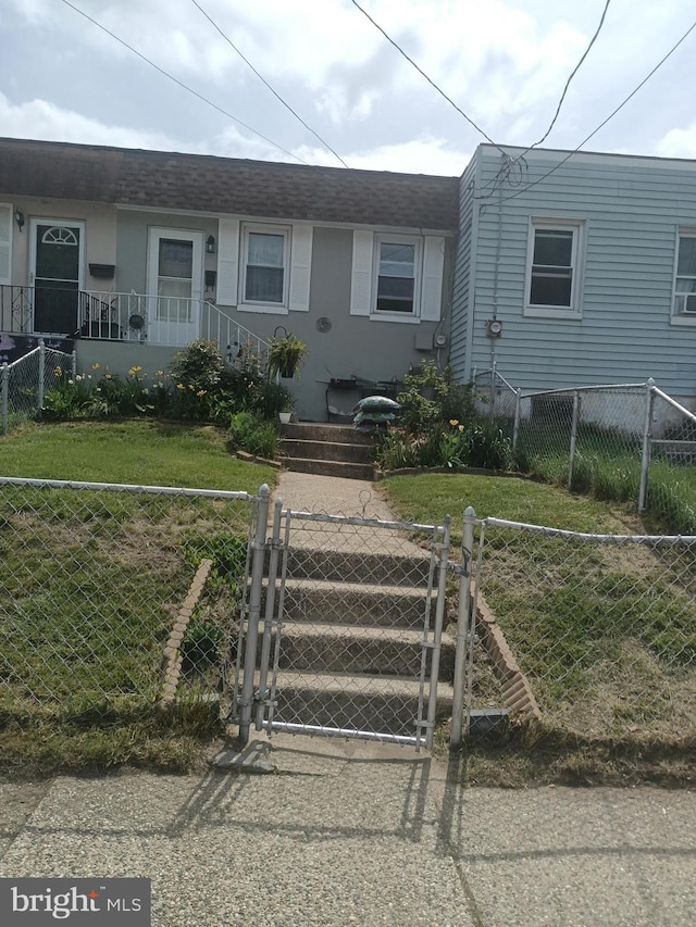 502 Page St, Woodbury, NJ 08096 - view of front of property with a gate, a front lawn, a fenced front yard, and stucco siding