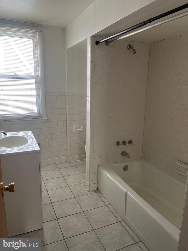 full bathroom with washtub / shower combination, vanity, tile patterned floors, and tile walls