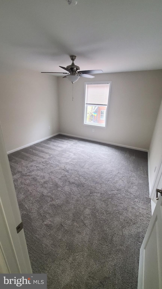 spare room featuring carpet, baseboards, and a ceiling fan